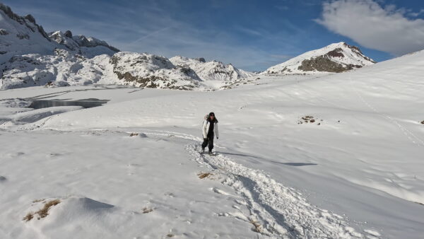 Participante camina hacia el ibón de Estanés en una ruta de raquetas de nieve en Jaca