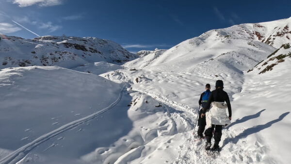 Participantes de una ruta de raquetas en Jaca caminando por terreno nevado hacia el Ibon de Estanés